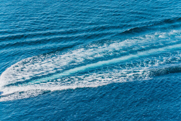 Trail on water surface behind of fast moving motor boat