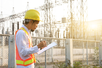 Engineers are reviewing and taking notes of electrical operation reports.