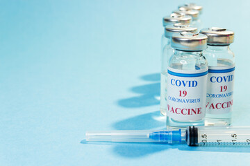 Vaccination against coronavirus. COVID 19 coronavirus vaccine. Glass bottle with injection solution and syringe. Copy space.
