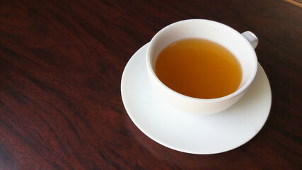 Hot tea leaves in white ceramic cup with beautiful cups put boiled water, hot tea leaves. Placed on a piece of chocolate-colored parquet Tea leaves are popular with people all over the world. Used to 