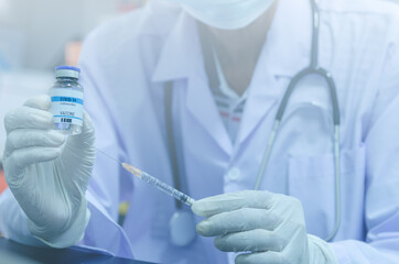 Male doctor holding a bottle of COVID-19 vaccine medicine Or the coronavirus vaccine and syringe