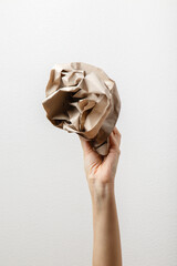crumpled gray craft paper in female hand. Separate collection of paper garbage. Woman hand. Paper stuff for recycle. Eco friendly people. Woman's hand holds recyclable paper waste. Zero waste