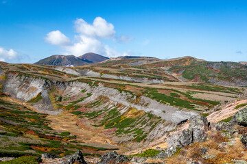 北海道・大雪山系の赤岳山頂から見た、山頂周辺に広がる紅葉と青空