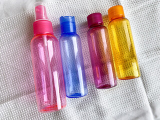 Colorful plastic travel bottles. Small containers for liquids like shower gel and shampoo. Face and body care products in compact size.
