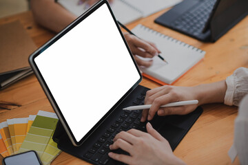 Fototapeta na wymiar Professional designer team Meeting together on the desk using a tablet. Blank white screen. Mock up.