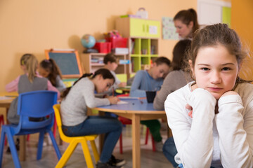 Fototapeta premium Portrait of schoolgirl and children drawing in classroom