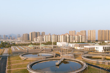 Water Purification Plant from Above, with modern city skyline at distance