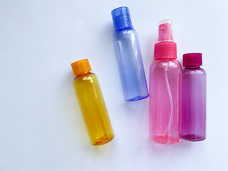 Colorful plastic travel bottles. Small containers for liquids like shower gel and shampoo. Face and body care products in compact size.
