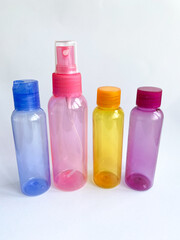 Colorful plastic travel bottles. Small containers for liquids like shower gel and shampoo. Face and body care products in compact size.