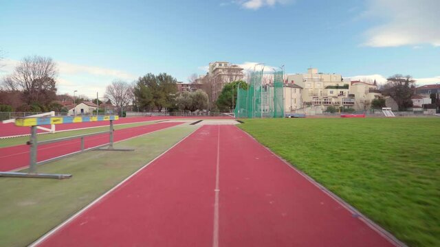 POV, athlete point of view shot of long jump or broad jump with landing in the sand, in an olympic stadium on a sunny day, practice run