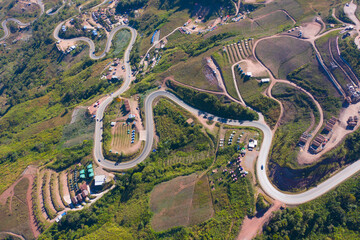 Aerial view of cars driving on curved, zigzag curve road or street on mountain hill with green...