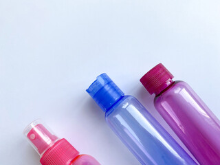 Colorful plastic travel bottles. Small containers for liquids like shower gel and shampoo. Face and body care products in compact size. Copy space