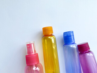 Colorful plastic travel bottles. Small containers for liquids like shower gel and shampoo. Face and body care products in compact size.