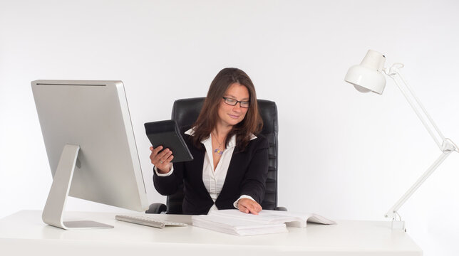 Woman accountant during work. Accountant with a calculator in his hands. Concept - work in an audit firm. Woman auditor next to the computer. Accountant on a white background. Audit business