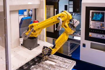 The manipulator hand processes metal parts. Yellow arm manipulator during work. Robotic production...