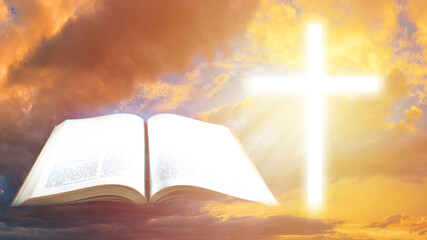 Bible next to the Catholic cross. Open book as a symbol of religious literature. Concept - Bible study. Reading Catholic literature. Bible study of Christianity. Sky in the background.