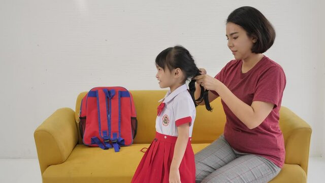 Asian family Mother dressed daughter to go to school of Thai families in their daily life.