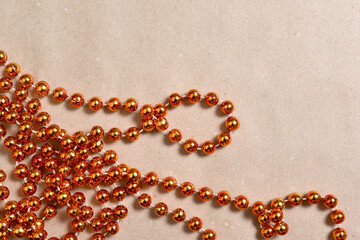 Background from beige craft paper, bottom orange round beads to decorate the Christmas tree.