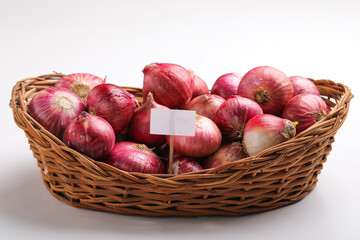 Red onions in wooden basket on white background