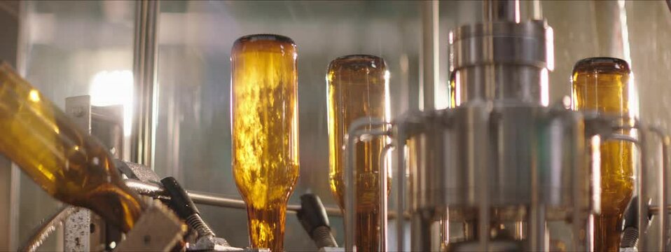 Brown glass bottles washed on a modern washing machinery in a factory. Factory concept.