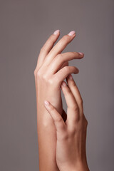 Closeup image of beautiful woman's hands with light pink manicure on the nails.