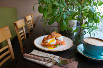 Breakfast with croissant and poached egg