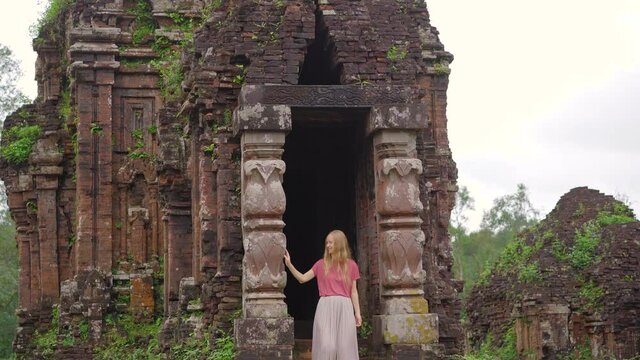 A young woman tourist is walking through ruins in the My Son Sanctuary, remains of an ancient Cham civilization in Vietnam.Tourist destination in the city of Danang. Travel to Vietnam concept