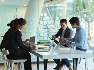 Businesspeople meeting on their work in glass wall partition meeting room