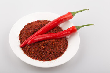 Korean chili pepper powder with chili peppers, on a white background.