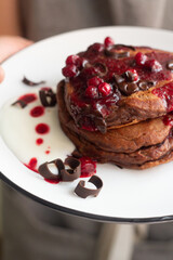 chocolate pancakes with berry sauce close-up
