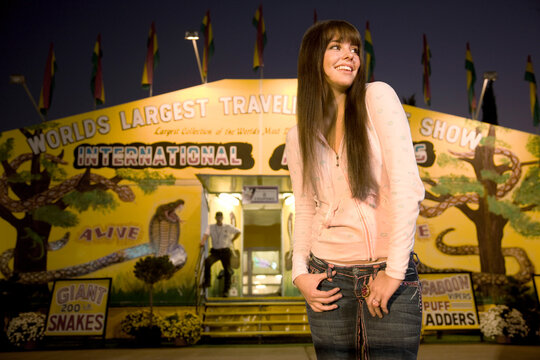 Teenage girl standing in an amusement park and smiling