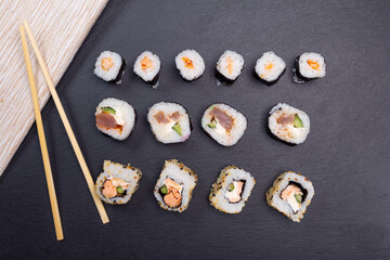 different types of sushi on a stone slab top view. traditional Japanese food