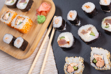 different types of sushi on a stone slab and bamboo plate. traditional Japanese dish