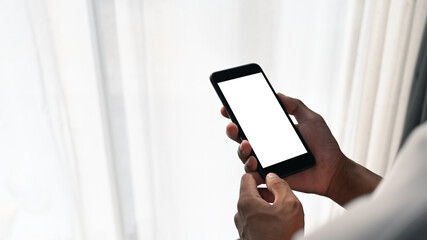 Mockup image of man hands holding mobile phone with blank white screen.