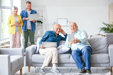 Senior people with different devices at home