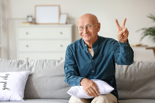 Senior Man Showing Victory Sign At Home