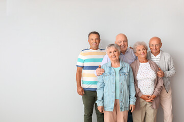 Fototapeta premium Senior people near light wall in room