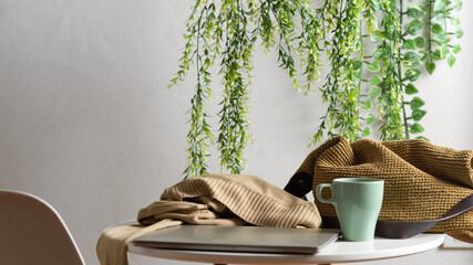 Laptop, mug, sweater and bag on the coffee table in Biophilia leisure corner