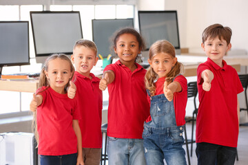 Little children showing thumb-up gesture in classroom
