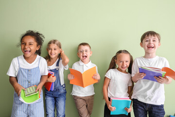 Happy little children with books on color background