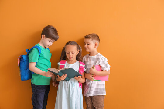 Little children with book on color background