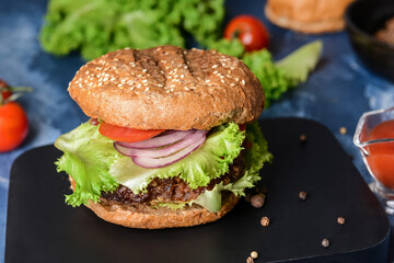 Tray with tasty burger and ingredients on color background