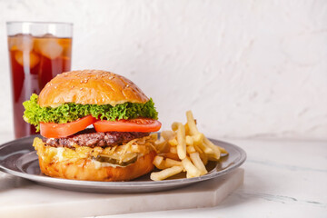 Tray with tasty burger and french fries on light background