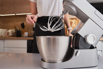 Woman using food processor to cooking in kitchen