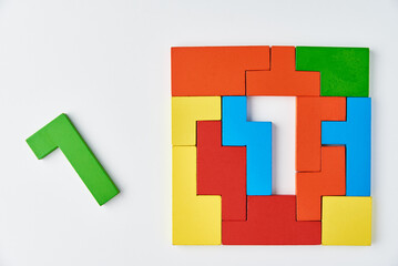 Logical thinking and finishing task concept. Different shapes colorful wooden blocks on white background