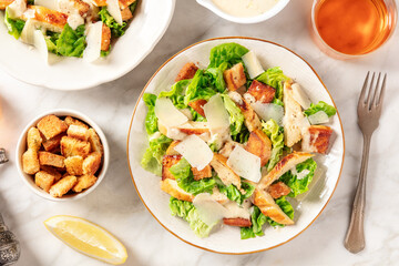 Caesar salad, shot from above on a white marble table