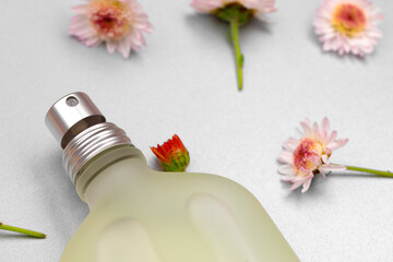 Bottle of fragrance surrounded by flower buds