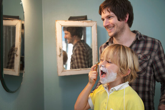 A man teaching to his son how to shave