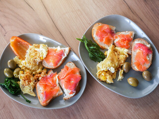 Healthy breakfast. Omelette with olives, pepper and arugula salad. Salmon with wholemeal bread.