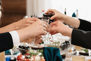 hands of people toasting and clinking glasses at a celebration